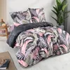 A neatly made bed with a floral duvet cover and pillows, a small side table with decorative items, and a potted plant in the background. Produktbild-Vorschau