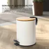 A white pedal bin with a wooden lid is shown on a wooden floor. Voir les images du produit
