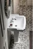 A white ceramic sink with a silver faucet is shown in a bathroom setting with patterned tiles. Anteprima dell’immagine prodotto