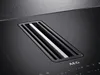 A close-up view of a black induction hob with an integrated extractor fan. Anteprima dell’immagine prodotto