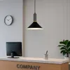 A modern office reception area with a desk, computer, clock, and a pendant light. Produktbild-Vorschau