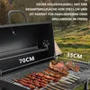 A charcoal grill with food cooking on it, set in an outdoor, grassy area with trees and a tent in the background. Produktbild-Vorschau
