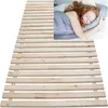 A woman sleeping on a bed with a wooden slatted base. Produktbild-Vorschau