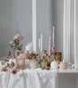 A collection of LED candles and decorative flowers arranged on a white lace tablecloth. Produktbild-Vorschau