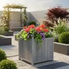 A garden scene with a wooden planter filled with flowers, a pergola with climbing roses, and a bench in the background. Voir les images du produit