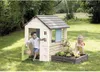 Two children are playing in a backyard with a playhouse and a planter box. Voir les images du produit