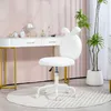 A white office chair with bunny ears sits in front of a white vanity table with makeup and a mirror. A potted plant is to the right. Podgląd zdjęcia produktu