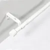 A white adjustable curtain rod mounted on a wall. Voir les images du produit