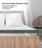 A mattress topper on a bed with pillows, next to a wicker chair, with text overlay describing the product's features. Produktbild-Vorschau