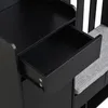 Close-up of an open drawer in a black furniture piece with a gray upholstered bench on the right. Produktbild-Vorschau