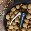 A bowl filled with walnuts and a nutcracker. Produktbild-Vorschau