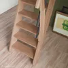 A close-up view of a wooden staircase with a metal railing. Produktbild-Vorschau