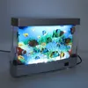 A decorative LED aquarium lamp with artificial fish and plants, lit from below and behind. Náhľad obrázku produktu