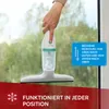 A hand is holding a cordless electric window cleaner against a window with water droplets. Produktbild-Vorschau