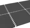 A close-up, angled view of dark gray interlocking floor mats. Voir les images du produit