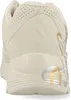 The back view of a cream-colored sneaker with gold and silver accents. Voir les images du produit