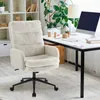A cozy, fluffy cream office chair is shown in a well-lit home office setting. Voir les images du produit