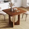 A wooden dining table with chairs in a modern kitchen setting. Voir les images du produit