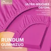 A close-up of a pink fitted sheet, showing its texture and elastic edge. Produktbild-Vorschau