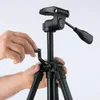 A close-up shot of a person's hands adjusting a black tripod. Anteprima dell’immagine prodotto