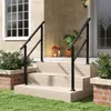 A black metal handrail is installed on a set of outdoor stairs leading to a house entrance. Voir les images du produit