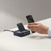 A hand is holding a smartphone near a multi-port charging station with a wireless charger. Anteprima dell’immagine prodotto