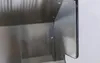 A close-up view of the interior of a stainless steel outdoor kitchen unit, showing the corner and some internal shelving. Produktbild-Vorschau