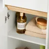 Close-up view of items inside a cabinet, including bottles of liquid and folded towels. Anteprima dell’immagine prodotto