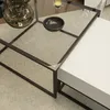 A close-up view of a modern coffee table with a glass top and a white drawer unit. Voir les images du produit