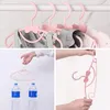 A collage of images showing pink clothes hangers with bow details, some holding clothes, and others demonstrating their strength with water bottles. Produktbild-Vorschau