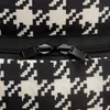 A close-up view of a black and white houndstooth pattern fabric with a black zipper. Produktbild-Vorschau