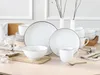 A set of white ceramic dishes with a brown rim, arranged on a wooden table. Náhľad obrázku produktu