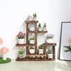 A wooden plant stand with multiple shelves holding various potted plants. Anteprima dell’immagine prodotto