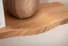 A close-up view of a wooden shelf with a wavy edge, showing the wood grain. A portion of a decorative object is visible on the shelf. Produktbild-Vorschau