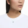 A woman wearing a white t-shirt and a silver necklace with a blue pendant. Produktbild-Vorschau