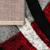 A close-up view of a rug with a geometric pattern, showing the texture and backing. Produktbild-Vorschau