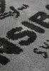 A close-up view of a textured rug with a pattern of letters. Produktbild-Vorschau