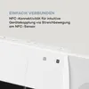 A close-up of the top section of a white stereo system, with text describing its NFC connectivity. Produktbild-Vorschau
