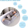 A woman is sleeping on a U-shaped pregnancy pillow in a bedroom. Náhled obrázku produktu