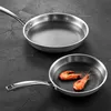 Two stainless steel frying pans on a dark textured surface. The smaller pan in the foreground contains two cooked shrimp. Náhľad obrázku produktu