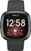 A close-up, front-facing view of a black Fitbit Sense 2 smartwatch with a black strap. The watch face displays the time, date, and fitness metrics. Produktbild-Vorschau