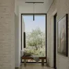 A modern hallway with a large window overlooking a garden, featuring a bench and a pendant light. Podgląd zdjęcia produktu