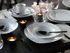 A table setting with plates, bowls, cups, cutlery, and candles. Náhľad obrázku produktu