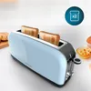 A blue toaster with two slices of toast in it, placed on a white surface with some baked goods in the background. Voir les images du produit
