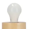A close-up shot of an LED light bulb sitting on a wooden base. Podgląd zdjęcia produktu