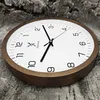 A wooden wall clock is placed on a textured surface that resembles tree bark. Voir les images du produit