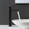 A black faucet with water flowing into a white sink. Náhled obrázku produktu