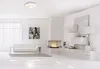 A modern, minimalist living room with a white sofa, fireplace, and wall-mounted shelving. Produktbild-Vorschau