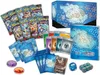 A collection of Pokémon trading card game items, including booster packs, energy cards, dice, and a storage box, arranged on a white background. Produktbild-Vorschau