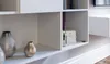 A close-up view of a white shelving unit with decorative vases and a small electronic device. Produktbild-Vorschau